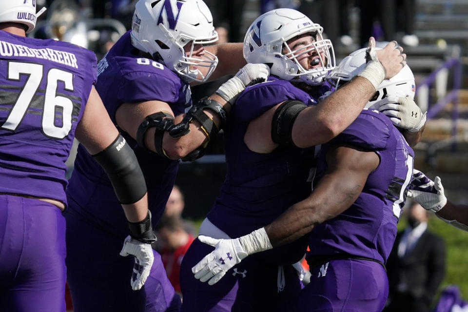 Northwestern running back Andrew Clair, right, celebrates with teammates after scoring a touchdown during the second half of an NCAA college football game against Rutgers in Evanston, Ill., Saturday, Oct. 16, 2021. Northwestern won 21-7. (AP Photo/Nam Y. Huh)