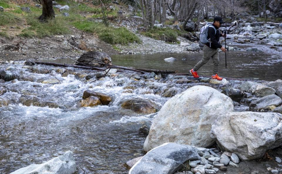 A hiker crosses the East Fork of the San Gabriel River.