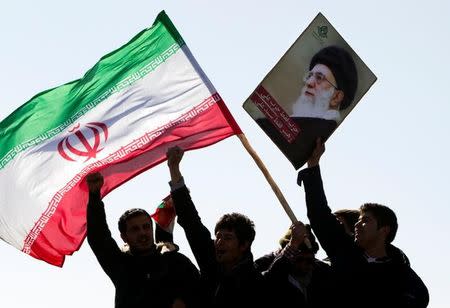 FILE PHOTO: Demonstrators wave Iran's flag and hold up a picture of supreme leader Ayatollah Ali Khamenei during a ceremony to mark the 33rd anniversary of the Islamic Revolution, in Tehran's Azadi square February 11, 2012. REUTERS/Raheb Homavandi/File Photo
