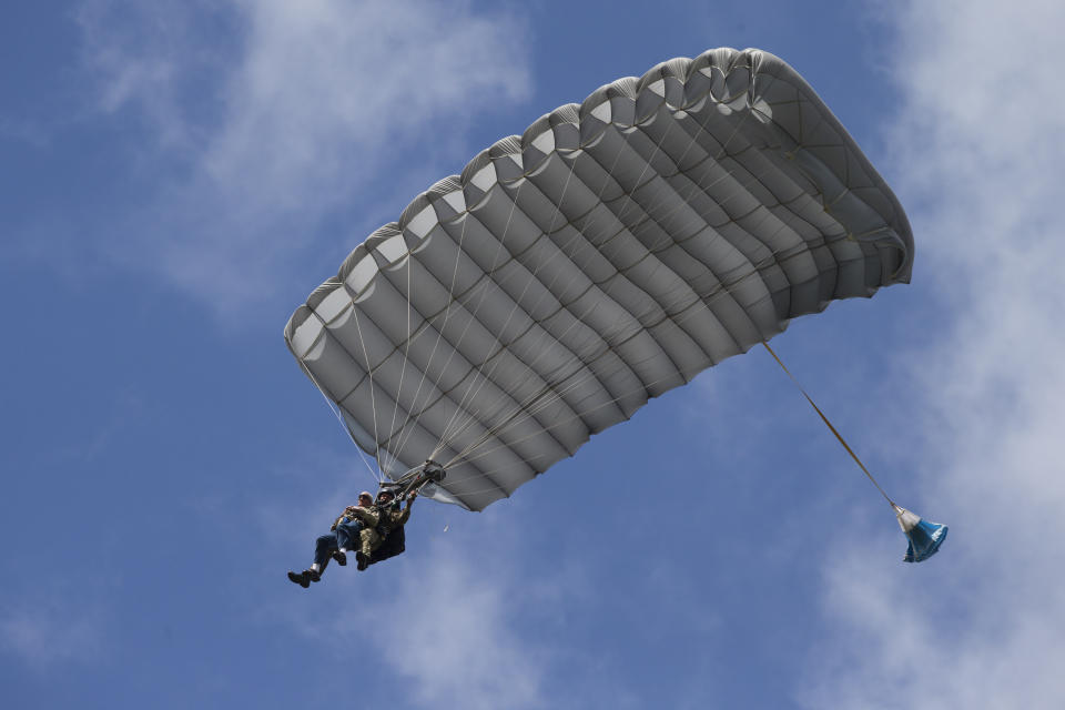 Tom Rice, a 98-year-old American WWII veteran, front left, approaches the landing zone during a tandem parachute jump near Groesbeek, Netherlands, Thursday, Sept. 19, 2019, as part of commemorations marking the 75th anniversary of Operation Market Garden. Rice jumped with the U.S. Army's 101st Airborne Division in Normandy, landing safely despite catching himself on the exit and a bullet striking his parachute. (AP Photo/Peter Dejong)