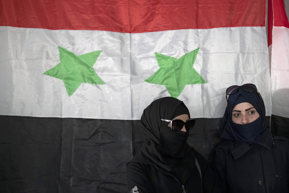 Syrian women prepare to vote in a presidential election, at a polling station in the town of Douma, near the Syrian capital Damascus, Syria, Wednesday, May 26, 2021. Syrians in government-held areas of the war-torn country are heading to polling stations to vote in presidential elections guaranteed to give President Bashar Assad a fourth seven-year term. (AP Photo/Hassan Ammar)