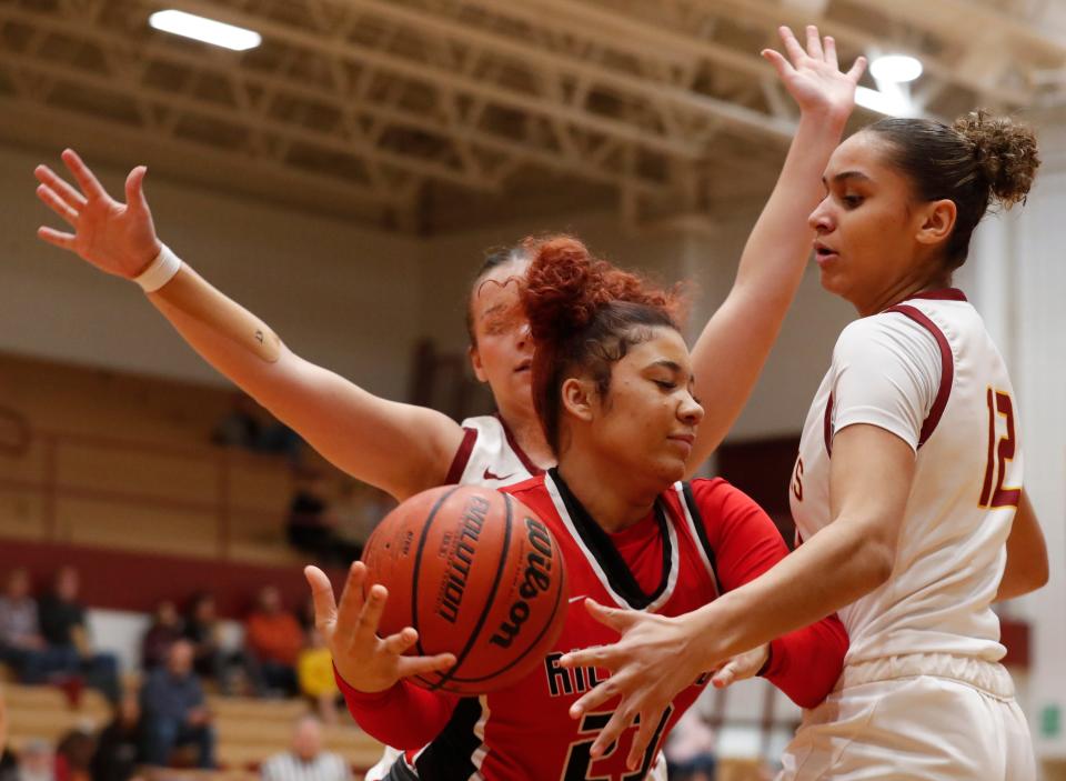 McCutcheon Mavericks guard Aubrey Miller (14) and McCutcheon Mavericks Lillie Graves (12) defend Richmond Red Devils guard Amyannah Tucker (23) during the IHSAA girl’s basketball game, Saturday, Jan. 6, 2024, at McCutcheon High School in Lafayette, Ind.