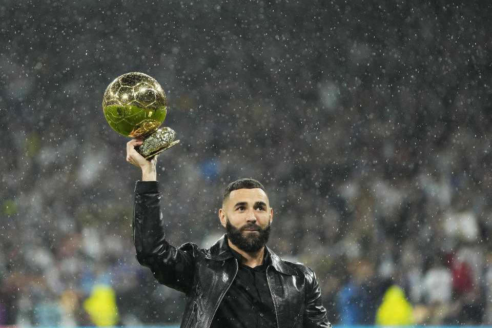 Real Madrid's Karim Benzema holds the 2022 Ballon d'Or trophy prior to the Spanish La Liga soccer match between Real Madrid and Sevilla at the Santiago Bernabeu stadium in Madrid, Saturday, Oct. 22, 2022. (AP Photo/Manu Fernandez)