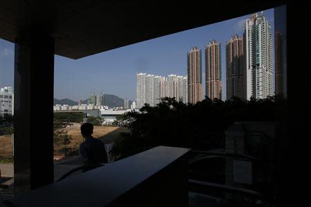 A man descends on an escalator near private housing estates in Hong Kong October 31, 2013. REUTERS/Bobby Yip