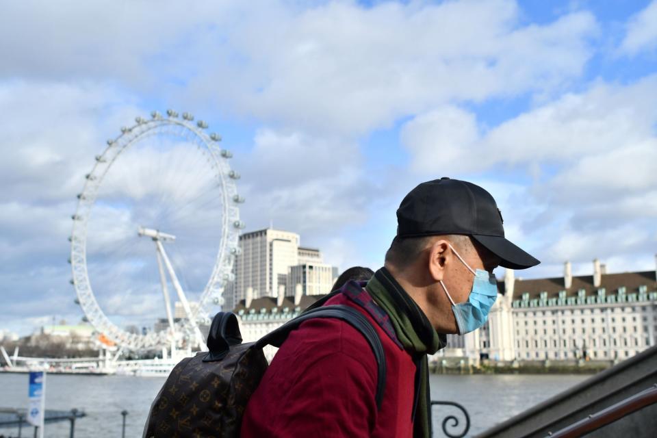 A man is seen wearing a mask while walking along the Thames (AFP via Getty Images)