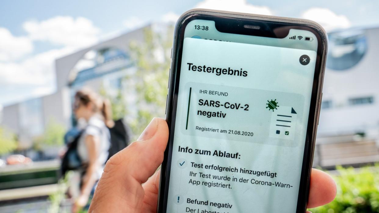 Ein für einen Reiserückkehrer durchgeführter Corona-Test wird auf dem Display eines iPhone in der Corona-Warn-App als "negativ" dargestellt.