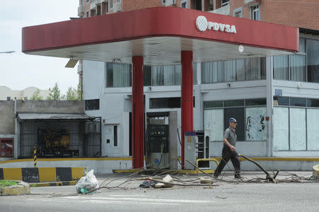 A man walks past a closed gas station of the state oil company PDVSA in San Cristobal, Venezuela, May 17, 2019. REUTERS/Carlos Eduardo Ramirez