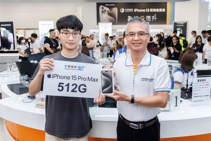 中華電信董事長郭水義(右)將全新原色鈦金屬iPhone 15 Pro Max (512G)交予幸運抽中該獎項的現場排隊客戶。（圖／中華電提供）