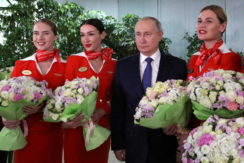 Russian President Vladimir Putin pictured congratulating women