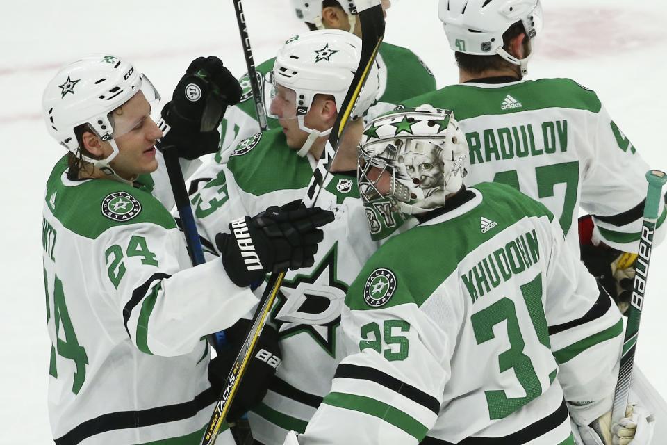 Dallas Stars goaltender Anton Khudobin (35) celebrates a win against the Arizona Coyotes with Stars left wing Roope Hintz (24), defenseman Esa Lindell (23) and right wing Alexander Radulov (47) as time expires in an NHL hockey game, Sunday, Dec. 29, 2019, in Glendale, Ariz. The Stars defeated the Coyotes 4-2. (AP Photo/Ross D. Franklin)
