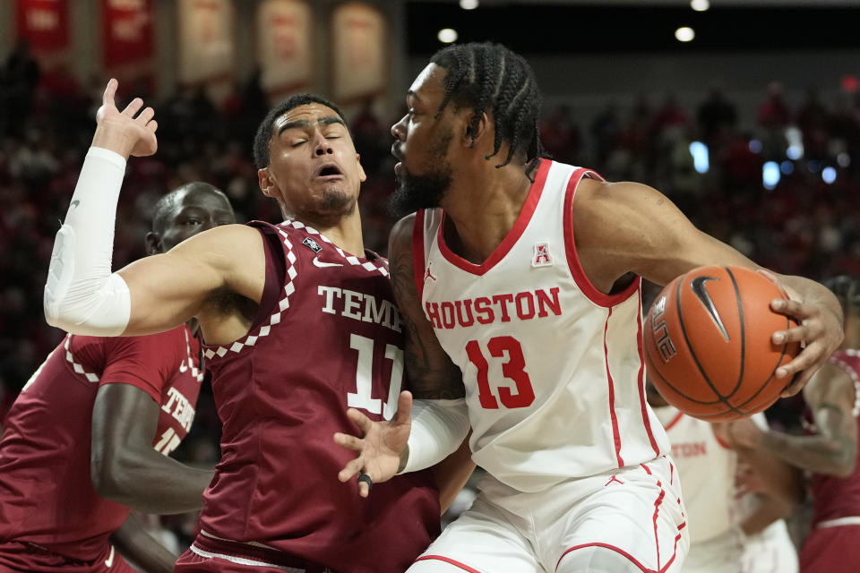 Houston's J'Wan Roberts (13) charges into Temple's Nick Jourdain (11) during the first half of an NCAA college basketball game Sunday, Jan. 22, 2023, in Houston. (AP Photo/David J. Phillip)