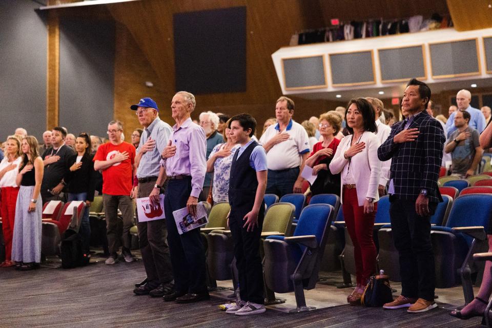 Attendees stand for the pledge of allegiance during the first 2nd Congressional District debate at Woods Cross High School in Woods Cross on Tuesday, June 20, 2023. | Ryan Sun, Deseret News