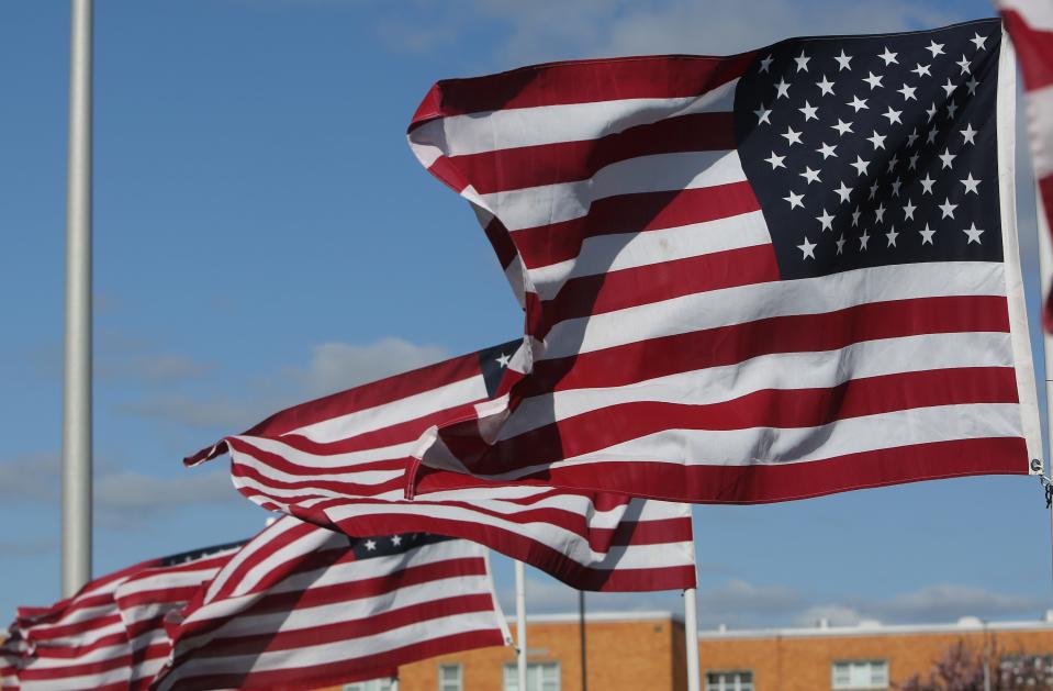 American flags blow in the wind outside of William Penn High School.