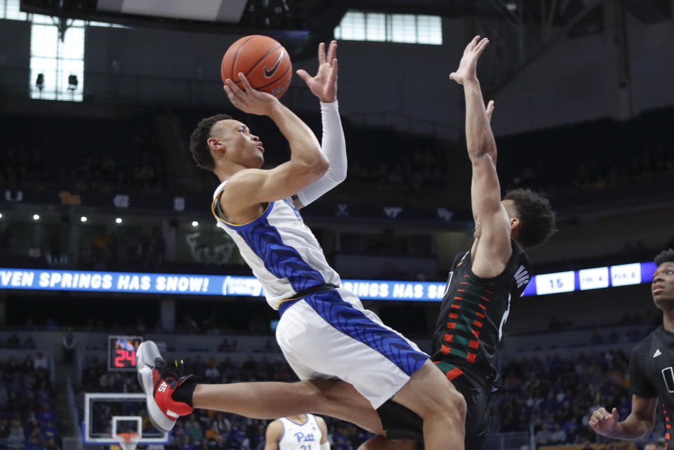 Pittsburgh's Trey McGowens, left, shoots as Miami's Isaiah Wong, right, defends during the first half of an NCAA college basketball game, Sunday, Feb. 2, 2020, in Pittsburgh. (AP Photo/Keith Srakocic)