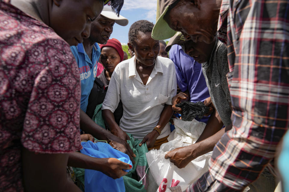 Residents receive relief food after El Niño rains damaged their houses in Bangale town in Tana River county, Kenya, on Sunday, Nov. 26, 2023. Severe flooding in the country has killed at least 71 people and displaced thousands, according to estimates from the UN Office for the Coordination of Humanitarian Affairs. (AP Photo/Brian Inganga).