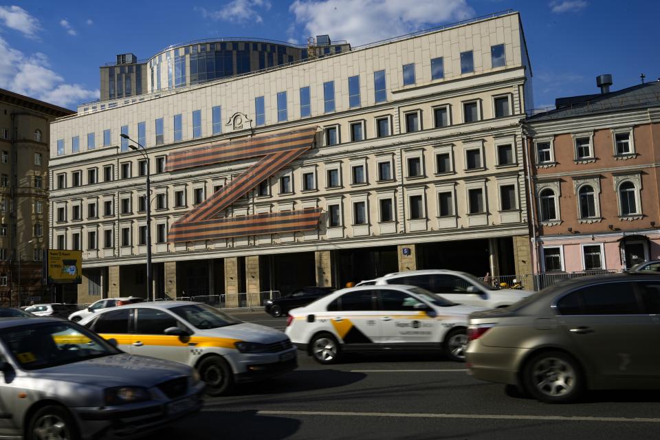 Cars drive along a street with a huge letter Z, which has become a symbol of the Russian military on a building in a street in Moscow, Russia, Friday, May 6, 2022. (AP Photo/Alexander Zemlianichenko)