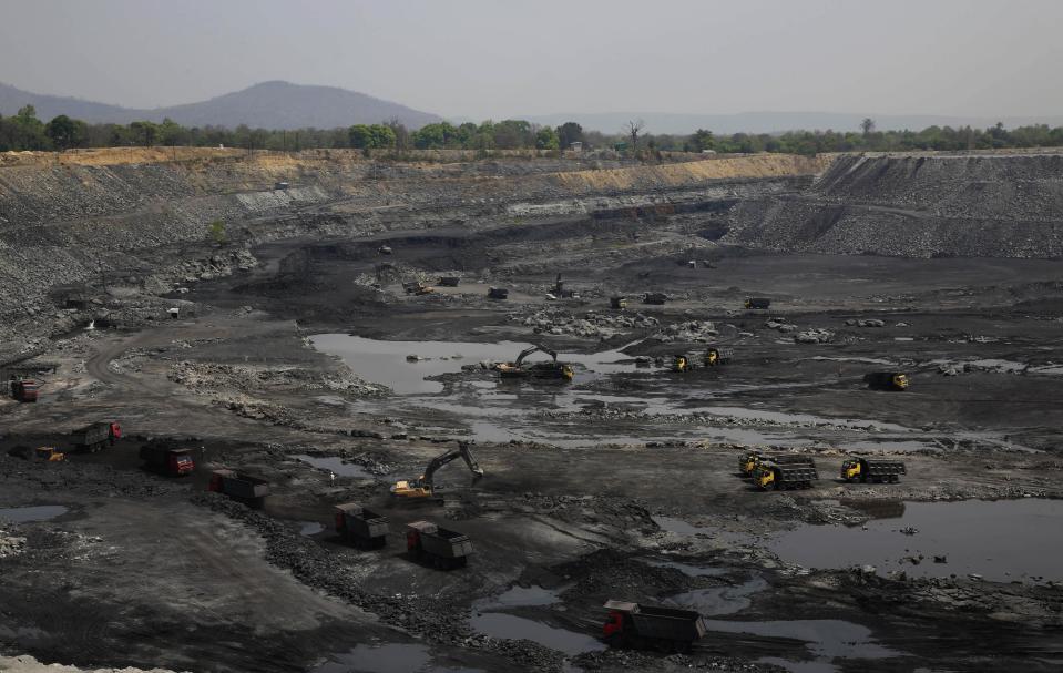 This April 15, 2014 photo, shows mining in progress at an open coat pit that belongs to Jindal Steel & Power Ltd. at Sarasmal village near the industrial city of Raigarh, in Chhattisgarh state, India. Each morning the ground shakes violently beneath Sarasmal and the neighboring village of Gare as mining crews blast the open coal pit with dynamite, sending clouds of coal dust into the air. (AP Photo/Rafiq Maqbool)