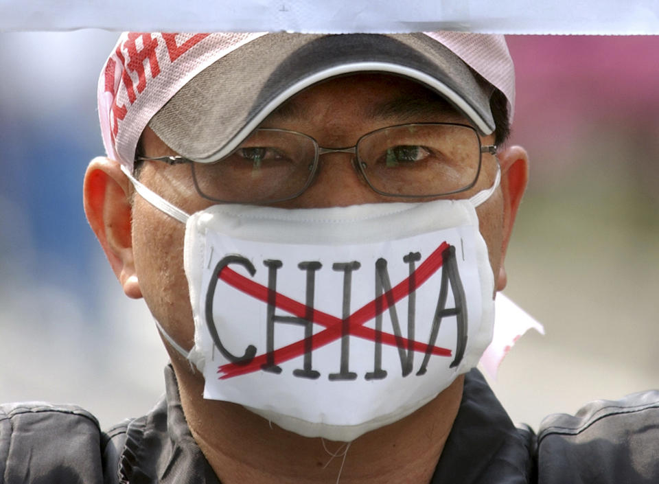 File - In this March 26, 2005, file photo, a pro-Taiwan supporter wears a face mask denouncing China and its anti-secession law in Taipei, Taiwan. The residents of this self-governing island are supporting their president Tsai Ing-wen as she stands up to China’s calls for unification with the mainland. (AP Photo/Wally Santana, File)