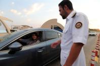 Immigration officer assists a Saudi woman at a Bahrain-Saudi border checkpoint