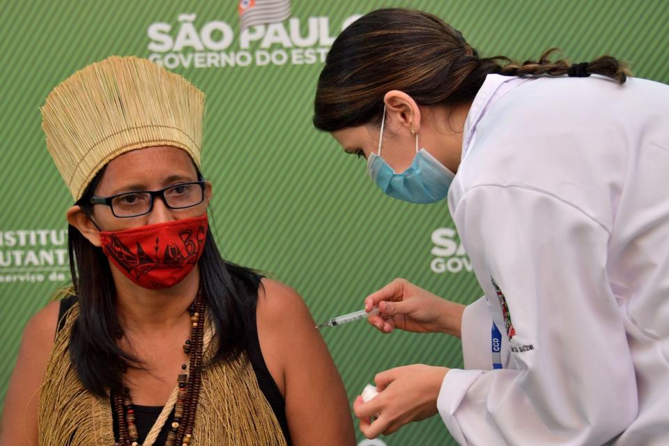 Brazilian woman wearing indigenous dress getting COVID-19 vaccine