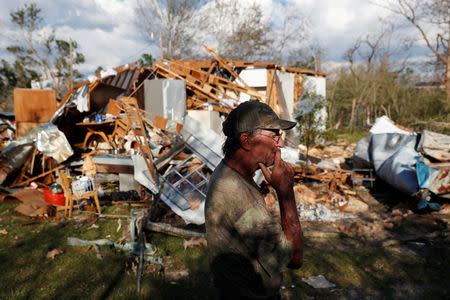 Bernard Sutton, 64, walks past the remains of his home destroyed by Hurricane Michael in Fountain, Florida, U.S., October 15, 2018. REUTERS/Terray Sylvester