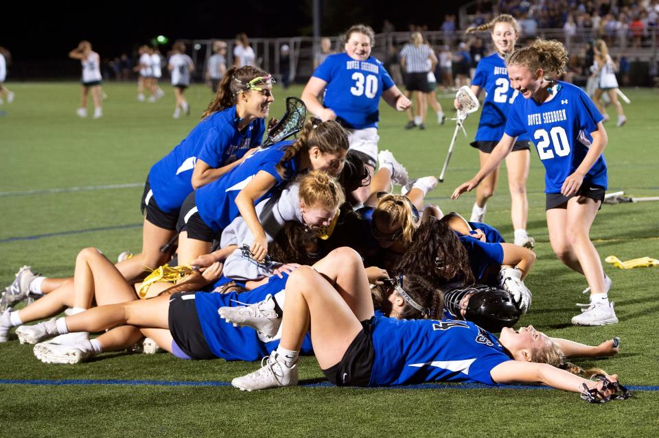 Members of the Dover-Sherborn varsity girls lacrosse team celebrate after defeating Manchester-Essex 10-7 in the Division 4 state championship game at Babson College in Wellesley, June 21, 2022.  