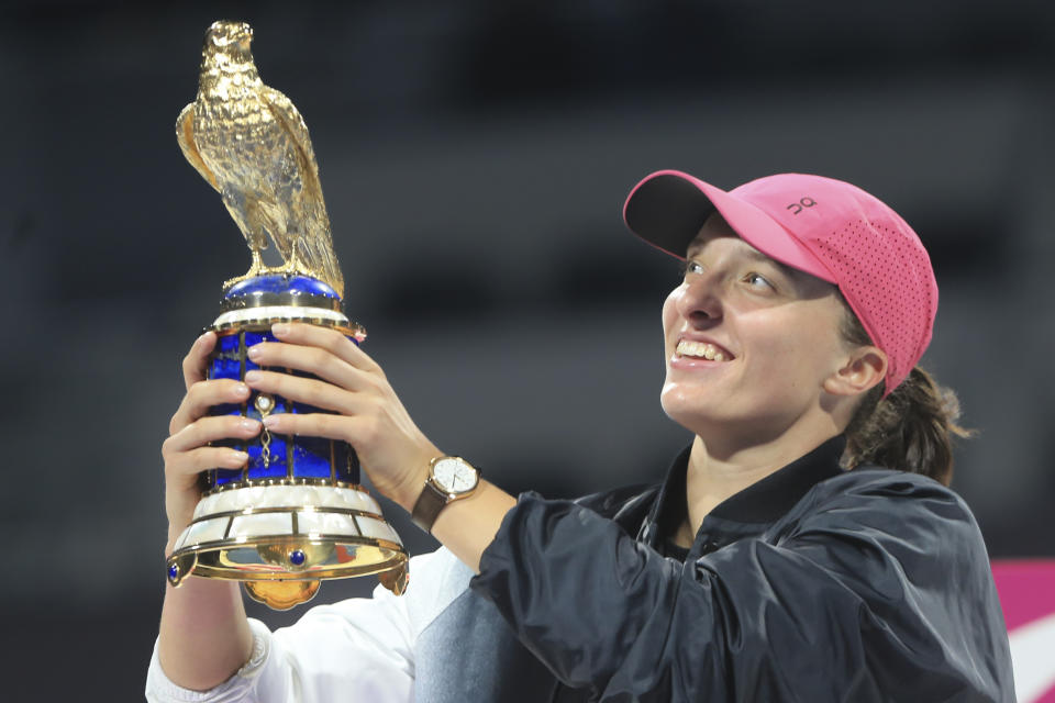 Poland's Iga Swiatek holds the trophy after winning the Qatar Open final against Kazakhstan's Ekaterina Rybakina in Doha, Qatar, on Saturday, Feb. 17, 2024. (AP Photo/Hussein Sayed)