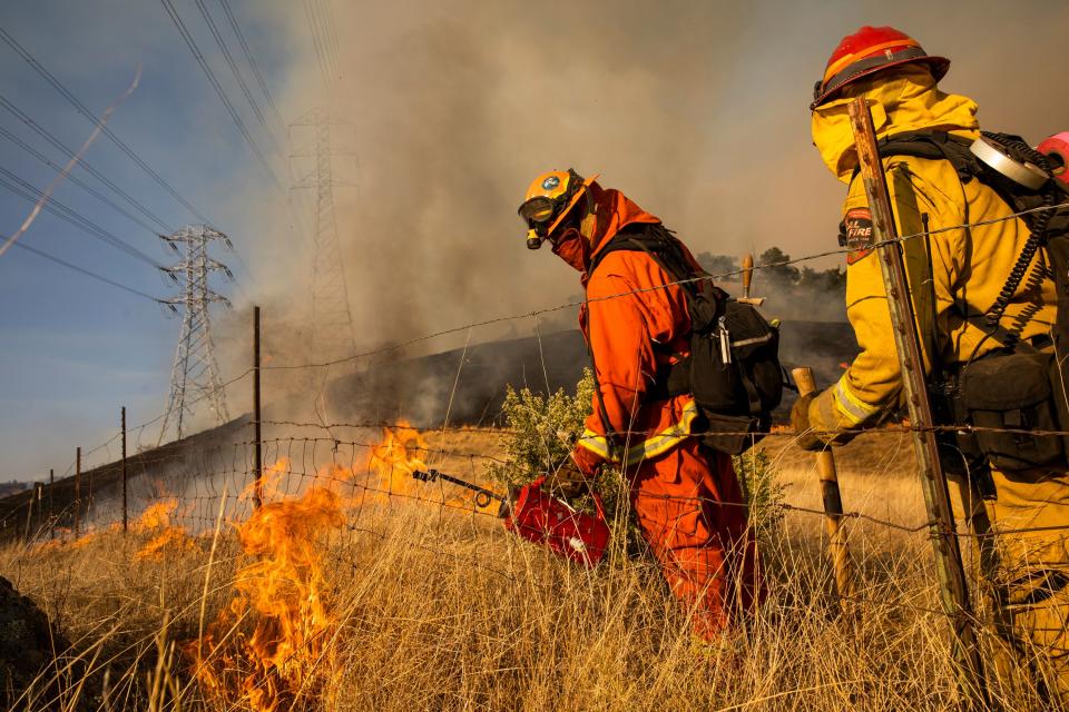 Firefighters set a back fire along a hillside near PG&E power lines during firefighting operations to battle the Kincade Fire in Healdsburg, California on October 26, 2019. - US officials on October 26 ordered about 50,000 people to evacuate parts of the San Francisco Bay area in California as hot dry winds are forecast to fan raging wildfires. (Photo by Philip Pacheco / AFP) / The erroneous source appearing in the metadata of this photo by Philip Pacheco has been modified in AFP systems in the following manner: [AFP] instead of [www.philippachecophoto.com]. Please immediately remove the erroneous mention from all your online services and delete it from your servers. If you have been authorized by AFP to distribute it to third parties, please ensure that the same actions are carried out by them. Failure to promptly comply with these instructions will entail liability on your part for any continued or post notification usage. Therefore we thank you very much for all your attention and prompt action. We are sorry for the inconvenience this notification may cause and remain at your disposal for any further information you may require. (Photo by PHILIP PACHECO/AFP via Getty Images)