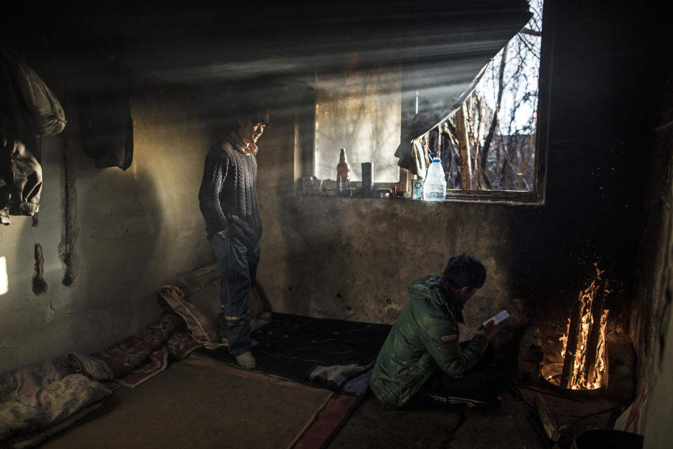 Afghan migrants warm up inside an abandoned factory used by migrants as shelter, before making another attempt to cross into Croatia in the outskirts of Bihac, northwestern Bosnia on Dec. 14, 2019.(Photo: Manu Brabo/AP)    