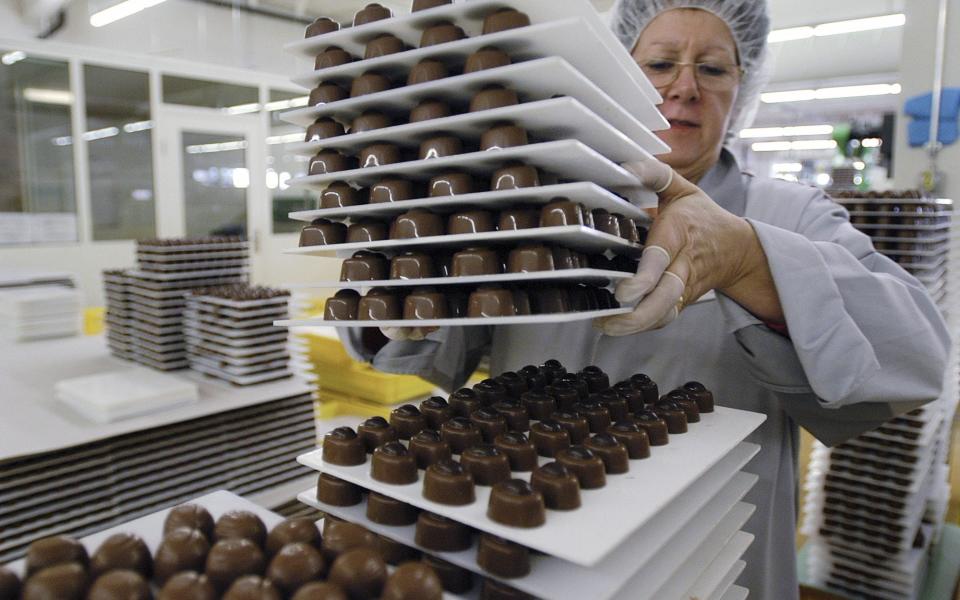 A worker stacks chocolates at the Nestle factory in Broc, Switzerland, 2004