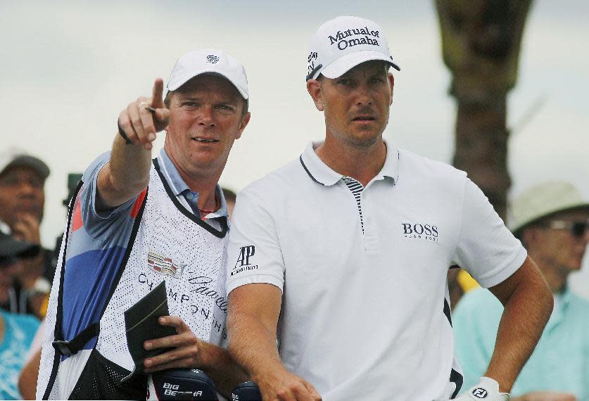 Henrik Stetson, right, of Sweden, listens to his caddie Gareth Lord from the second tee during the first round of the Cadillac Championship golf tournament Thursday, March 6, 2014, in Doral, Fla. (AP Photo/Marta Lavandier)