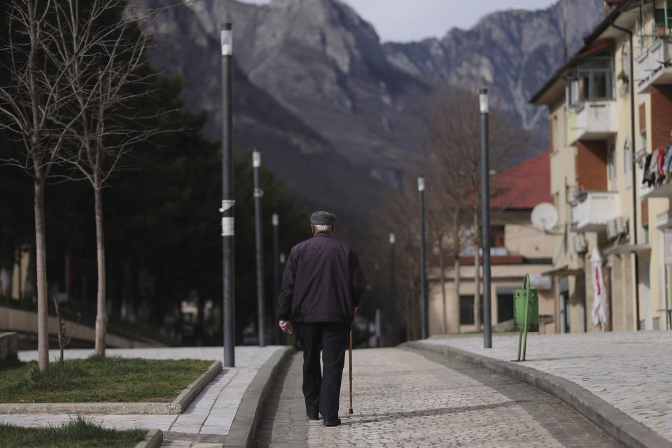 An old man walks on a pedestrian street in the city center of Bajram Curri, 240 kilometers (150 miles) northern of Tirana, Albania, Tuesday, March 14, 2023. Thousands of young Albanians have crossed the English Channel in recent years to seek a new life in the U.K. Their dangerous journey in small boats or inflatable dinghies reflects Albania's anemic economy and a younger generation’s longing for fresh opportunities. (AP Photo/Franc Zhurda)
