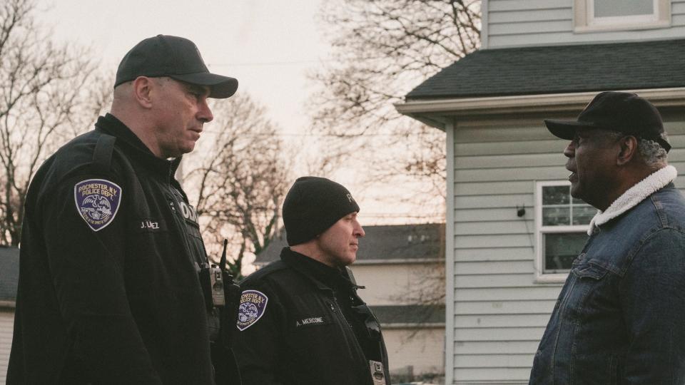 Officers James Laruez and Angelo Mercone talk with Rev. Dr. Julius C. Clay, leader of New Beth Christian Methodist Episcopal Church.