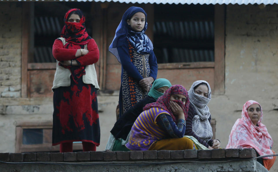 Kashmiri women and girls watch the funeral procession of a civilian Uzair Mushtaq in Kulgam 75 Kilometers south of Srinagar, Indian controlled Kashmir, Sunday, Oct. 21, 2018. Three local rebels were killed in a gunbattle with Indian government forces in disputed Kashmir on Sunday, and six civilians were killed in an explosion at the site after the fighting was over, officials and residents said. (AP Photo/Mukhtar Khan)