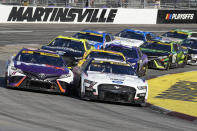 Ryan Blaney (12) and Denny Hamlin (11) battle as they lead the field out of Turn 2 during a NASCAR Cup Series auto race at Martinsville Speedway in Martinsville, Va., Sunday, Oct. 29, 2023. (AP Photo/Chuck Burton)