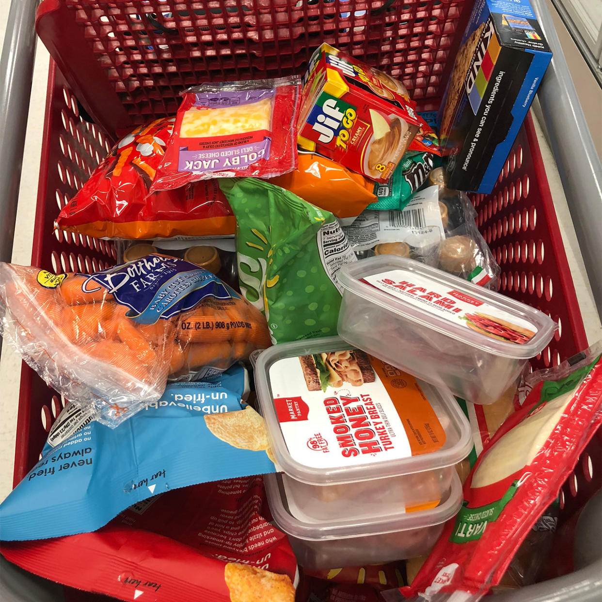 shopping cart full of processed meats cheese and chips