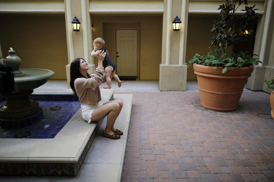 FILE - In this Aug. 24, 2018 file photo Keira Sumimoto plays with her daughter, in Irvine, Calif. Sumimoto, who used marijuana briefly for medical reasons while pregnant and breastfeeding, says her daughter is healthy and advanced for her age. More than three years after California voters approved broad legalized marijuana, a state panel is considering if the potent high-inducing chemical THC found in pot should be declared a risk to pregnant women and require warnings to consumers. (AP Photo/Gregory Bull,File)