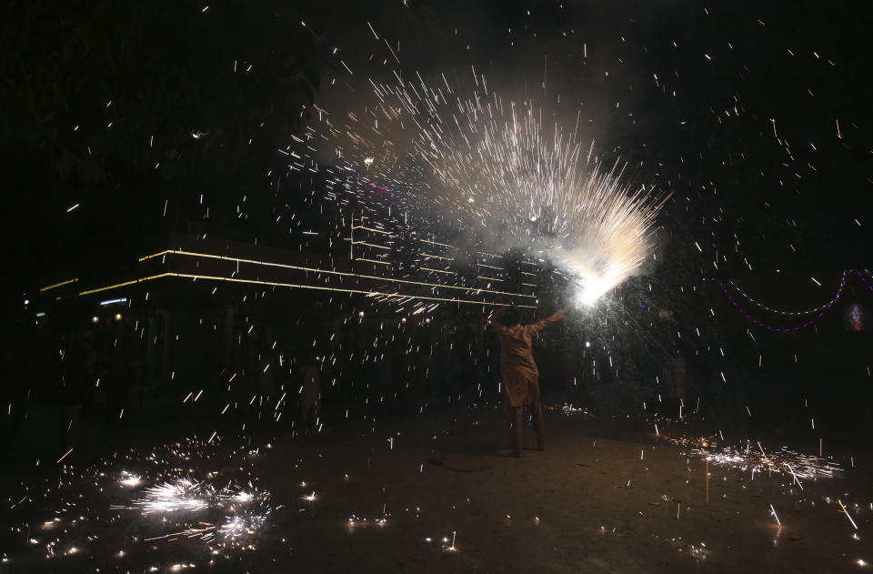A Hindu holds a firework at a ceremony to celebrate Diwali, the festival of lights, at a temple in Karachi, Pakistan, Friday, Nov. 4, 2021. The Hindu festival of lights, Diwali celebrates the spiritual victory of light over darkness. (AP Photo/Fareed Khan)