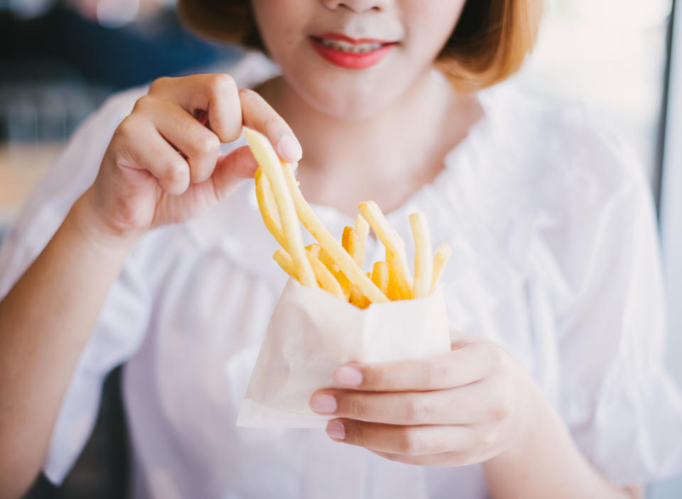 Woman eats french fries