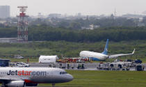 A Jetstar passenger plane taxis upon landing while a Xiamen Air, right, sits on the grassy portion of the runway of the Ninoy Aquino International Airport after it skidded off the runway while landing Friday, Aug. 17, 2018 in suburban Pasay city, southeast of Manila, Philippines. All the passengers and crew of Xiamen Air Flight 8667 were safe and were taken to an airport terminal, where they were given blankets and food before being taken to a hotel. The left engine is visible on the left. (AP Photo/Bullit Marquez)