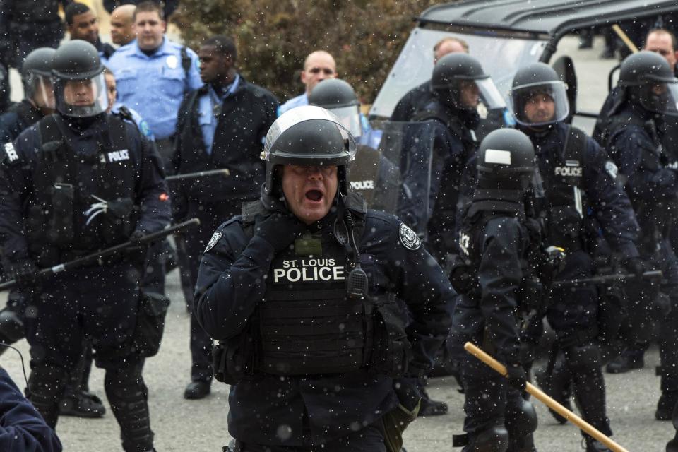 Police officers confront demonstrators after a group tried to force their way into City Hall during a protest against the decision of a grand jury regarding the death of Michael Brown in St. Louis, Missouri November 26, 2014. Police arrested scores of people in cities around the United States who were protesting a Missouri grand jury's decision not to indict a white police officer for killing an unarmed black teenager, authorities said on Wednesday, but the town where the shooting took place was a little calmer. (REUTERS/Lucas Jackson)