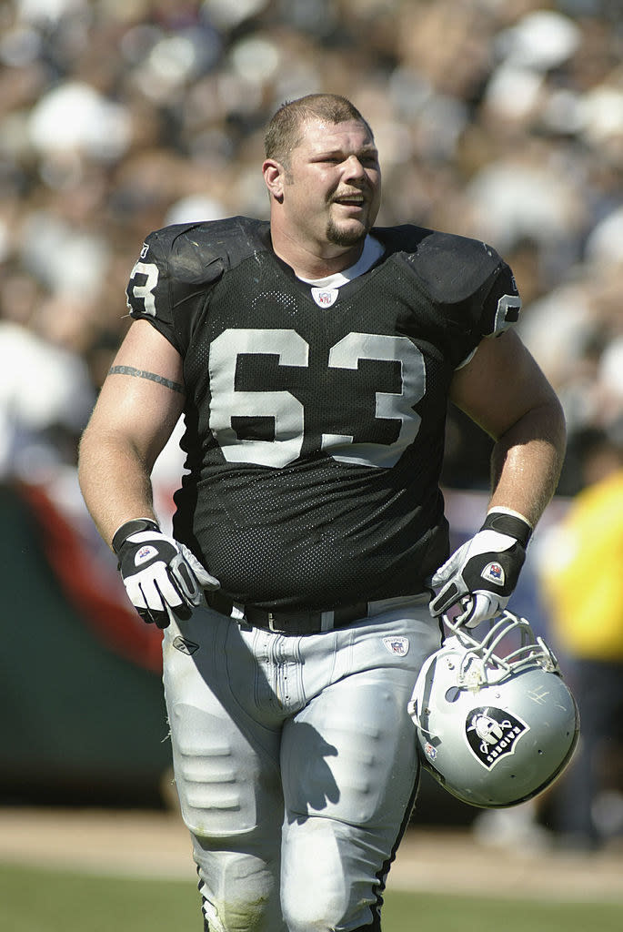 Robbins on the field holding his helmet in hand