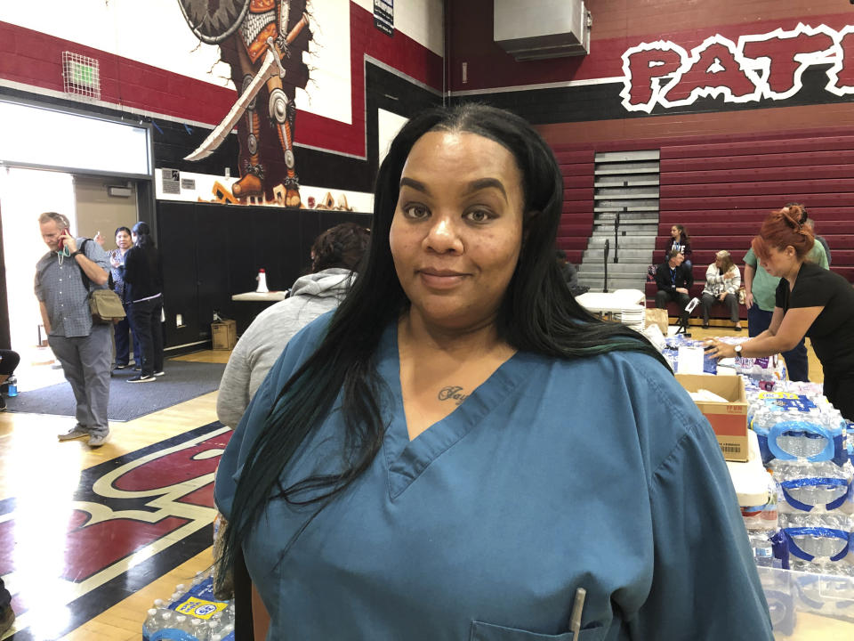 Qiana McCracken, assistant director of nursing at Riverside Heights Healthcare Center, said they were given 15 minutes warning to evacuate the facility on Wednesday, Oct. 30, 2019, from a brush fire in the hills. McCracken called 911 and helped get residents out of the facility, who were taken to a nearby school in Jurupa Valley, California. (AP Photo/Amy Taxin)