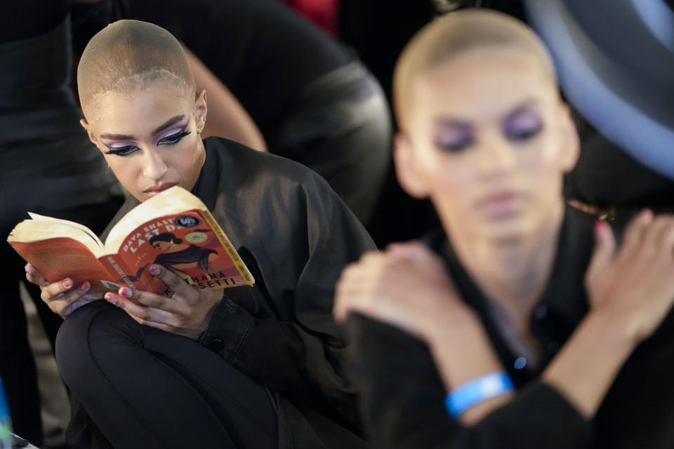 A model reads a book backstage while waiting to get her make-up and hair done before modeling the Sergio Hudson collection during Fashion Week, Saturday, Feb. 11, 2023, in New York. (AP Photo/Mary Altaffer)