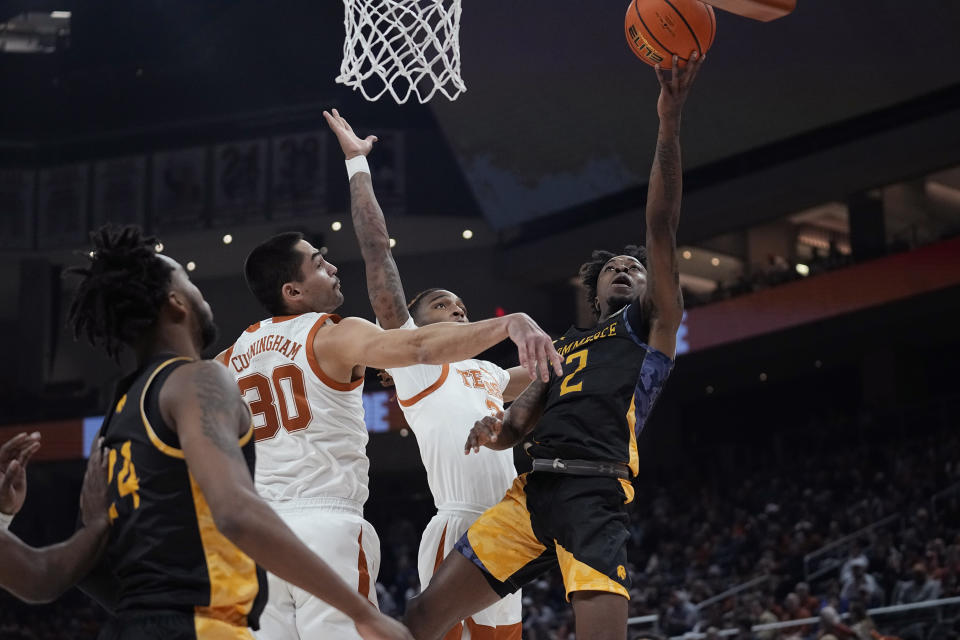 Texas A&M-Commerce guard Kalen Williams (2) drives to the basket against Texas forward Brock Cunningham (30) and guard Arterio Morris (2) during the first half of an NCAA college basketball game in Austin, Texas, Tuesday, Dec. 27, 2022. (AP Photo/Eric Gay)
