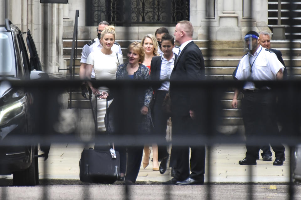 U.S. actress Amber Heard, centre left, departs from the High Court, in London, Monday, July 27, 2020. Hollywood actor Johnny Depp is suing News Group Newspapers over a story about his former wife Amber Heard, published in The Sun in 2018 which branded him a 'wife beater', a claim he denies. (AP Photo/Alberto Pezzali)