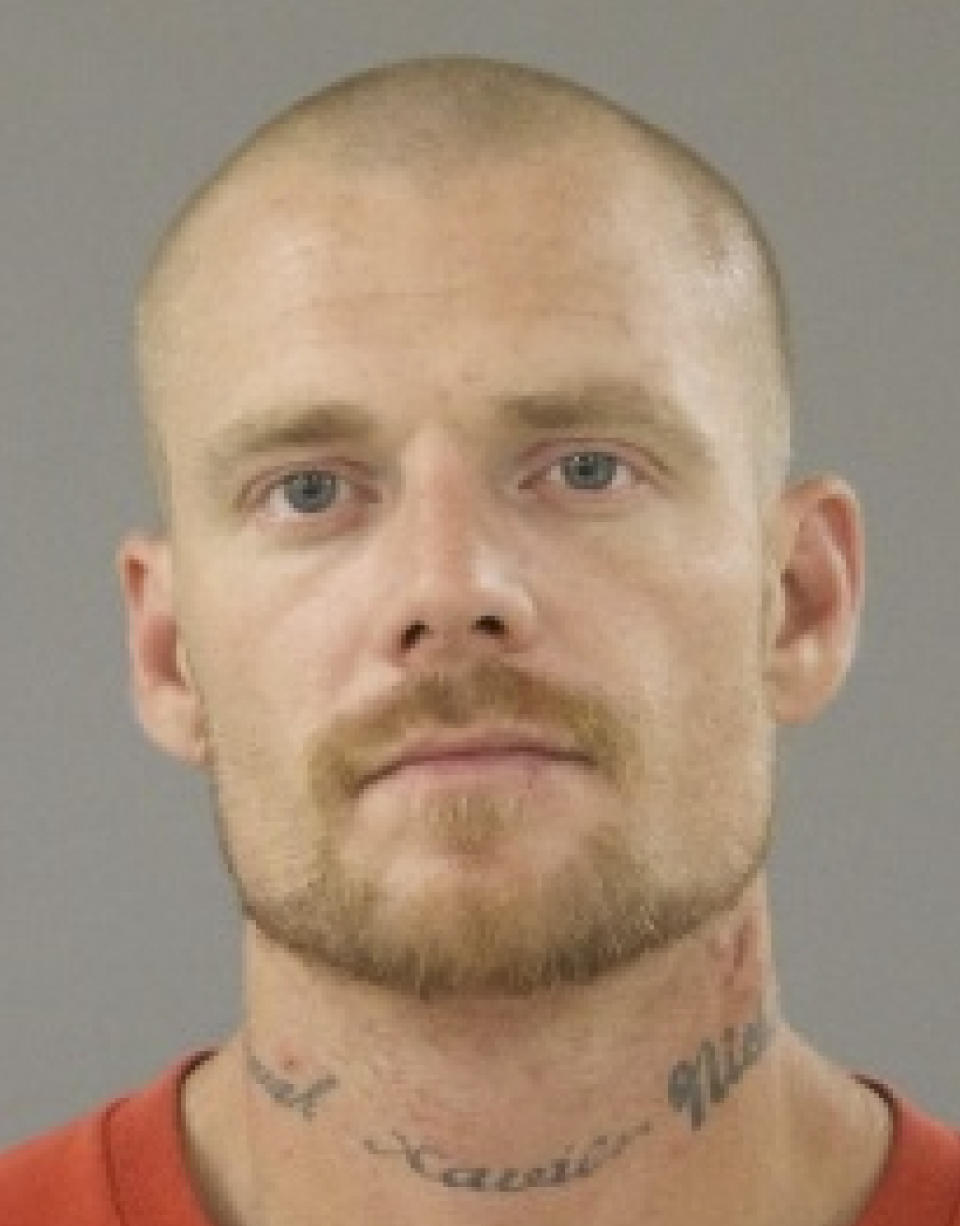This booking photo provided by the Rockford, Ill., Police Department shows Nicholas August, 39, who was charged Saturday, Jan. 4, 2020, with armed robbery, aggravated criminal sexual assault and unlawful restraint. He is being held on $2 million bail. Police say he entered a Rockford, Ill., bank on Friday, took a woman hostage and sexually assaulted her during a standoff with police. (Rockford Police Department via AP)