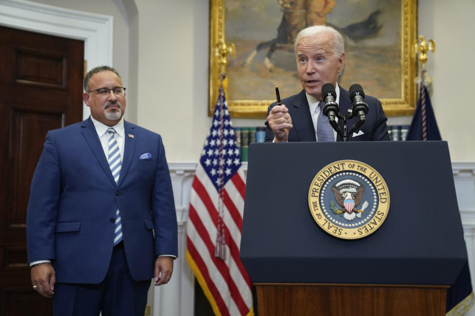 FILE - President Joe Biden speaks in the Roosevelt Room of the White House, Friday, June 30, 2023, in Washington. Education Secretary Miguel Cardona listens at left. In the wake of a Supreme Court decision that removes race from the admissions process, colleges are coming under renewed pressure to put an end to legacy preferences, the practice of favoring applicants with family ties to alumni. Biden suggested that colleges should rethink the practice after the court’s ruling, saying legacy preferences “expand privilege instead of opportunity.”(AP Photo/Evan Vucci, File)