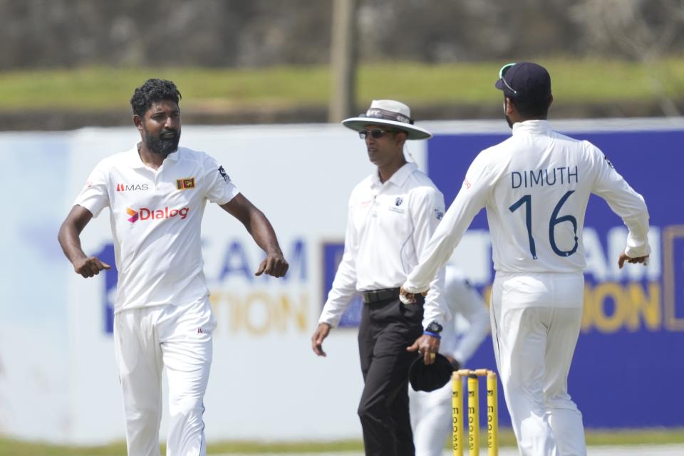 Sri Lanka's Prabath Jayasuriya, left, celebrates taking the wicket of Australia's Alex Carey with teammate Dimuth Karunaratne during the second day of the second test cricket match between Australia and Sri Lanka in Galle, Sri Lanka, Saturday, July 9, 2022. (AP Photo/Eranga Jayawardena)