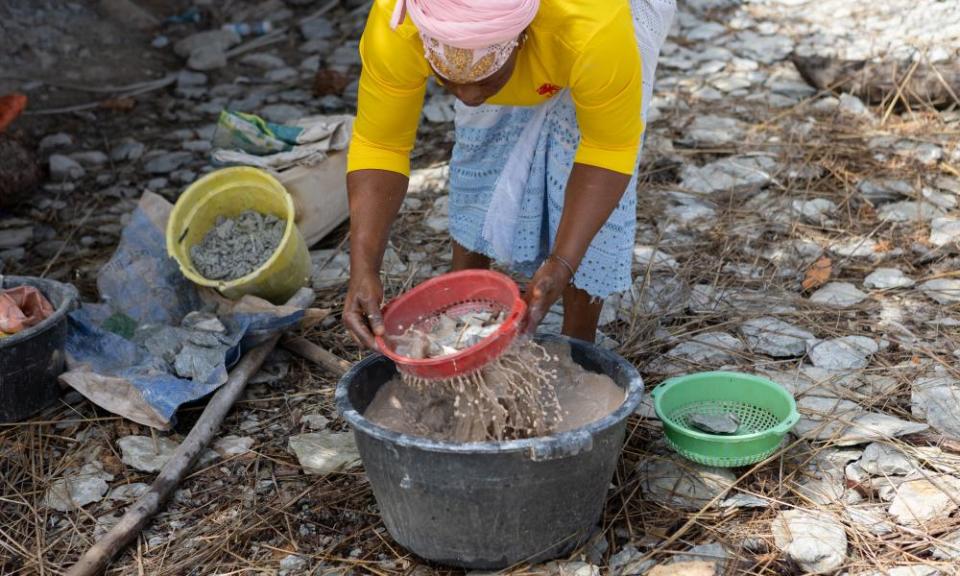 A woman sifts through sediment for gold